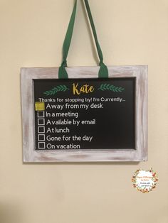 a chalkboard sign hanging on the wall with a green ribbon around it's edge