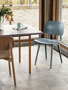 two chairs sitting next to each other on top of a tile floor near a table