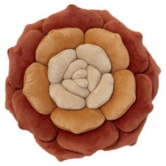 an orange and brown flower shaped pillow on a white background with the center piece in the middle