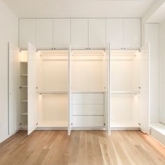 an empty room with white closets and wooden floors