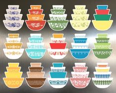 a bunch of bowls sitting on top of a metal wall next to each other in different colors