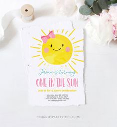 a card with a sun on it next to some flowers and twine spools