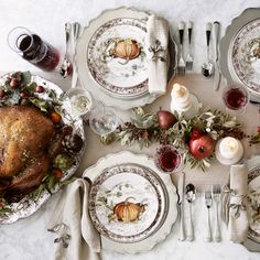 a table set for thanksgiving dinner with turkey and apples