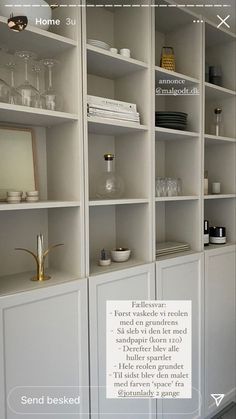 a white bookcase filled with lots of books next to a wall covered in shelves