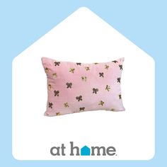 a pink pillow with gold butterflies on it and the words at home written in blue