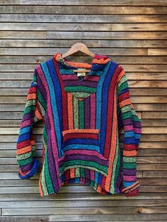 "super colorful baja hoodie is soft and great for beach hangouts. embrace your hippie side and cozy up to late summer campfires in this fun top. 100% acrylic top is super soft and made in mexico. maker: Franks condition: good (is nicely broken in) chest: 44\" length: 24\"" Long Sleeve Hoodie For Beach In Fall, Casual Multicolor Beach Sweater, Multicolor Winter Vacation Sweater, Multicolor Hippie Festival Sweater, Fun Multicolor Cotton Sweater, Bohemian Multicolor Sweater For Beach, Multicolor Bohemian Beach Sweater, Bohemian Multicolor Beach Sweater, Casual Multicolor Cotton Poncho