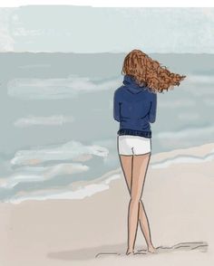 a woman standing on the beach with her hair blowing in the wind and looking at the ocean