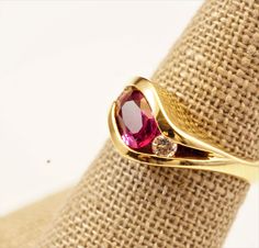 A high-quality, oval ruby engagement ring with two diamonds. A quality ruby ring with VVS diamonds in 14k yellow solid gold. The design is clean, elegant and makes a great anniversary ring, July Birthstone present. Metal: 14K yellow gold Gemstones: Natural, oval ruby, approximately 1.30-carat weight, A-grade, medium red, translucent, and measures approximately 7mm by 5mm in diameter. The two side, round diamonds are VVS clarity and I color; both stones are approximately 0.20 in total carat weigh Ring With Two Diamonds, Oval Ruby Engagement Ring, Ruby Diamond Engagement Ring, Ruby Band Ring, Ruby Bands, Vvs Diamond, Ruby Engagement Ring, July Birthstone, Ruby Diamond