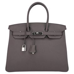 Mightychic offers an Hermes Birkin 35 Etain bag is the most perfect medium gray and is utterly neutral. This beauty is absolutely stunning with palladium hardware. Clemence leather is textured and highly scratch resistant. Comes with lock, keys, clochette, sleepers, raincoat and signature Hermes box. NEW or NEVER WORN. final sale BAG MEASURES: LENGTH 35 cm / 14" TALL 28 cm / 11" DEEP 18 cm / 7" HANDLES: TALL 5" CONDITION: NEW or NEVER WORN Elegant Taupe Shoulder Bag With Palladium Hardware, Elegant Taupe Shoulder Bag With Metal Hardware, Chic Epsom Leather Bag With Lock, Epsom Leather Bags With Lock For Everyday Use, Evening Bags With Lock In Epsom Leather, Evening Epsom Leather Bag With Lock, Luxury Gray Shoulder Bag With Palladium Hardware, Taupe Travel Bag With Palladium Hardware, Luxury Gray Bag With Palladium Hardware