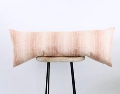 a pink pillow sitting on top of a wooden chair