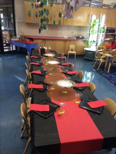 a long table is set up with black and red place mats