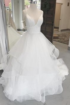 a white wedding dress on display in front of a mirror