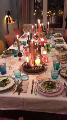 a table with plates and candles in the middle is set for a meal or dinner