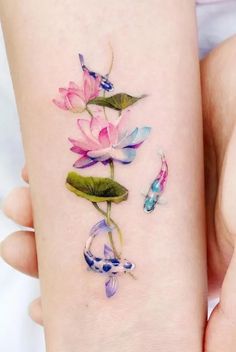 a woman's arm with water lilies and koi fish on it