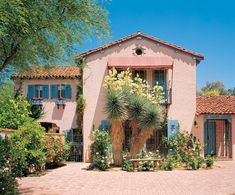 a pink house surrounded by greenery and trees