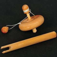 a wooden toy sitting on top of a black table next to a piece of string