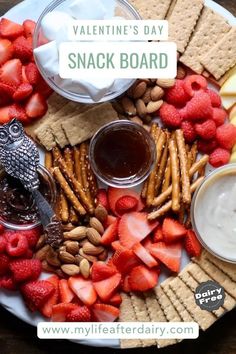 valentine's day snack board with strawberries, almonds, crackers and fruit