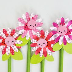 three paper flowers with ladybugs on them