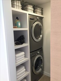 a washer and dryer in a small room with shelving on the wall