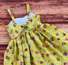 "Your little girl will love her sunny yellow ladybug twirl dress! The ladybugs are outlined in a sparkly, silver for a special touch. So perfect for the spring and summer, a birthday gift, a party or everyday fun! The bodice features a sweetheart neckline and is lined in a white cotton fabric. The keyhole back ties with a knot with elastic at the back for a comfortable fit. The dress is easy care 100% cotton with the perfect twirling factor! So much fun for play, parties and dress up occasions. Cute Yellow Sundress For A Garden Party, Cute Yellow Sundress For Garden Party, Cute Yellow Twirl Dress For Summer, Cute Yellow Summer Twirl Dress, Cute Yellow Dress For Picnic, Fun Spring Sundress For Playtime, Spring Sundress For Playtime, Cute Yellow Twirl Dress For Spring, Playful Yellow Twirl Dress For Spring