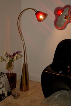 a lamp that is on top of a table next to a vase with flowers in it