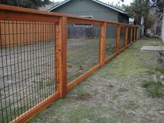 the fence is made of wood and has metal bars on each side, along with grass