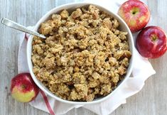 an apple crisp in a bowl with two apples