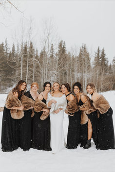 a group of women standing next to each other on top of a snow covered field