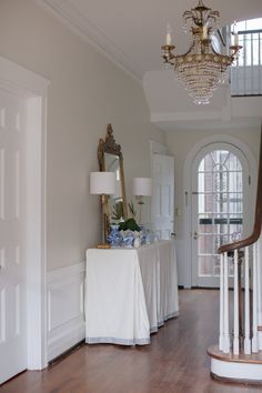 a table with a white cloth on it next to a chandelier in a room