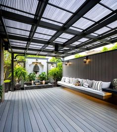 a wooden deck with benches and plants on it