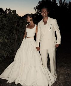 a man and woman dressed in white standing next to each other