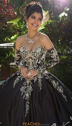 a woman in a black and gold dress posing for the camera with her hands on her hips