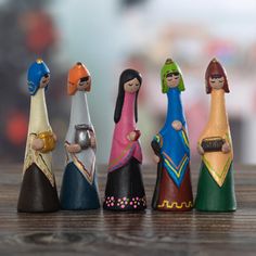 a group of small figurines sitting next to each other on top of a wooden table