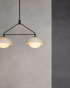 three lights hanging from a ceiling fixture in a room with concrete walls and flooring