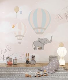 an elephant and hot air balloons wall mural in a child's room with toys on the floor