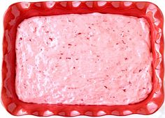 a red bowl filled with food on top of a white table