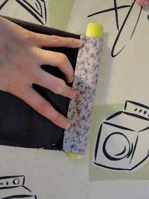 a woman's hand holding a roll of toilet paper on top of a table