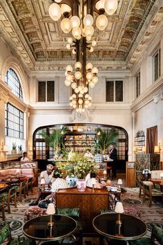 the interior of a restaurant with chandeliers and tables