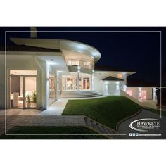 a large white house at night with lights on the front and stairs leading up to it