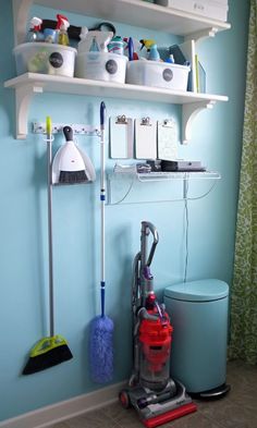 a room with blue walls and various cleaning tools on the wall, including a vacuum cleaner