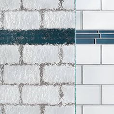 an image of a bathroom setting with white and blue tiles on the wall, shower head