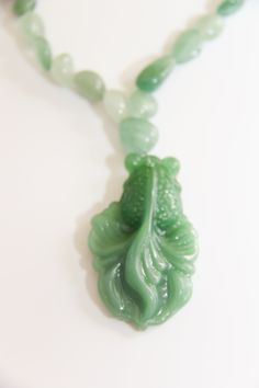 Hand carved big green glass Koi fish pendant dangling from small green Aventurine/jade nuggets necklace. 16" Whimsical Hand-Carved Glass Green Koi Fish Pendant: The Asian Koi fish is very spiritual and very lucky in all aspects of your life. Koi fish is the Chinese symbol of good luck, prosperity, & Tranquility. According to Feng Shui, a fish represents wealth and prosperity because the actual word in Chinese for fish, in Pinyin: yú, 魚, also translates to “abundance” The color green associated w Spiritual Jade Necklace For Good Luck, Handmade Jade Necklaces For Good Luck, Green Jade Amulet Necklace, Unique Green Carved Necklace, Spiritual Single Strand Jade Necklace, Unique Green Necklace With 108 Beads, Spiritual Green Jade Necklace, Green Jade Spiritual Necklace, Green Carved Amulet Necklace