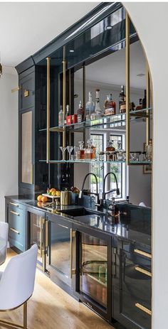 a kitchen with black cabinets and gold trim