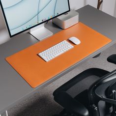 an office desk with a computer monitor, keyboard and mouse sitting on top of it