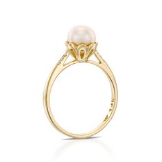 a pearl and diamond ring in yellow gold with diamonds on the sides, set against a white background