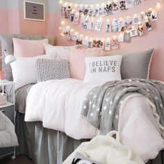 a bedroom decorated in pink, grey and white with pictures on the wall above the bed