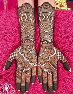 the hands and feet of a woman with henna tattoos on their arms, both decorated with