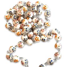 St. JP II Relic Rosary - Blessed by Pope Francis This is a precious ceramic rosary, made of shiny white ceramic beads with orange and blue flowers. Handmade by nuns, the imperfections are its beauty. Attached to it there is a silver tone medal with relic of St. John Paul II, our beloved Pope. 24 inches long. You can bring this unique rosary and our beloved smiling pope always with you. The rosary and the copyrighted metal cross are made in Italy. This rosary has already been blessed, but it can San Juan Pablo Ii, Saint Peter Square, St John Paul Ii, Fleur Orange, John Paul Ii, Flowers Handmade, Colorful Ceramics, Metal Cross, Rosary Catholic