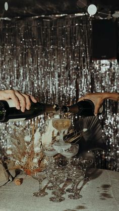 two people pouring champagne into glasses on a table