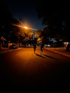 two people walking down the street at night